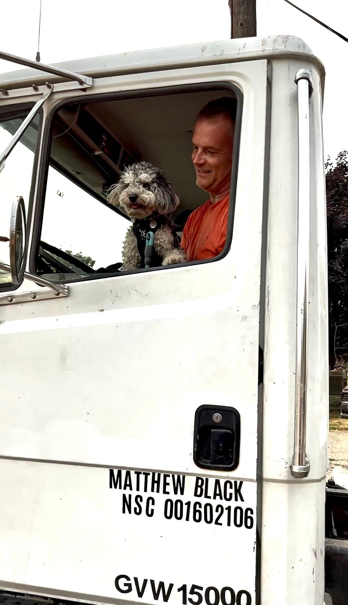 The owner and the shop dog in the cab of the Le Pew Septic truck